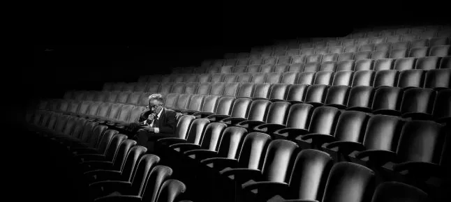 A man sitting alone in a theater.